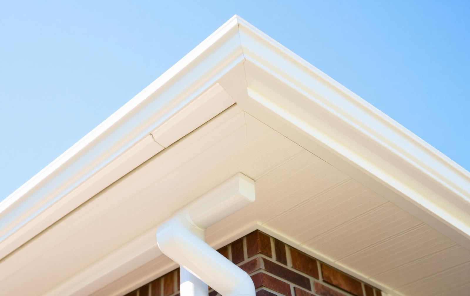 Newly installed seamless gutters and downspout on a home roofline
